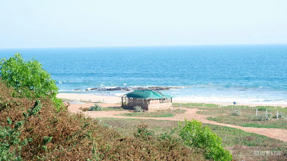 高清摄影 一个 gazebo 坐落在沙滩上，紧挨着海边的沙丘之中。