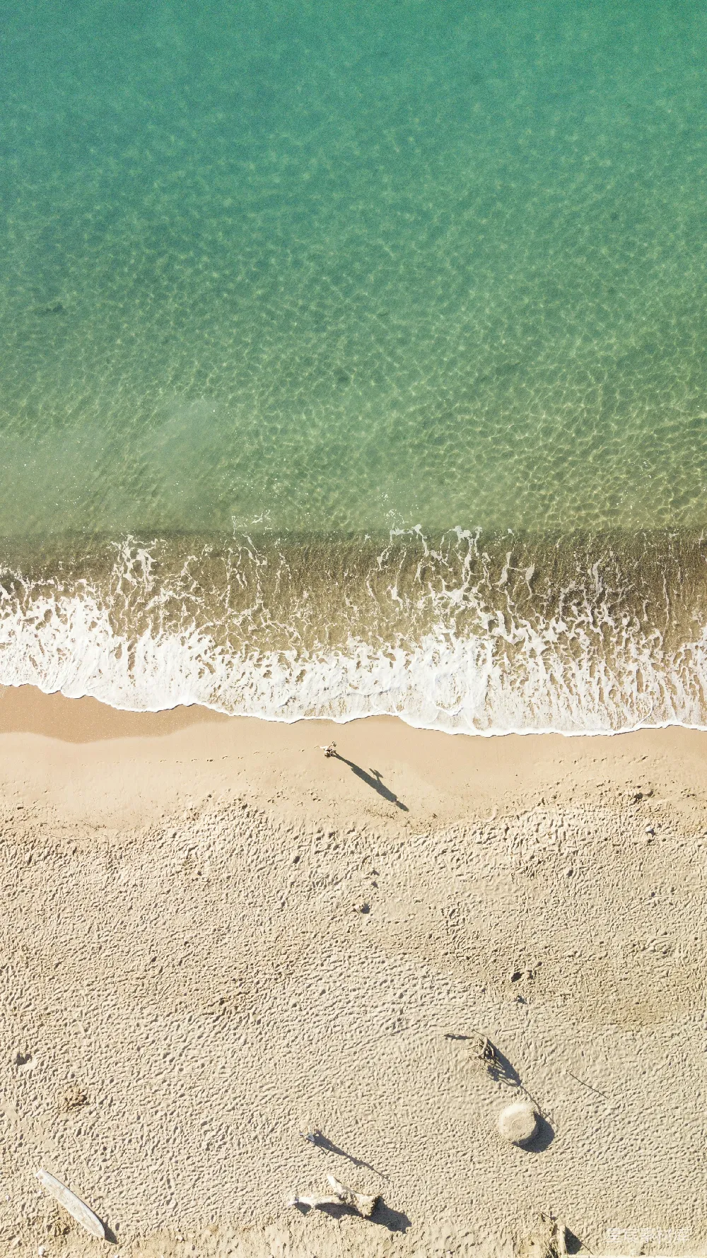 高清摄影 一片沙子覆盖的海滩，海浪拍打而来