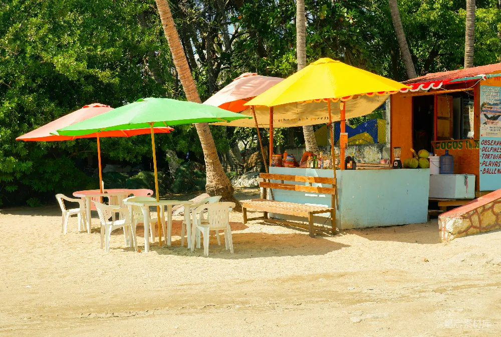 高清摄影 彩色的海滩遮阳伞和一家沙滩小贩车 snacks shack。