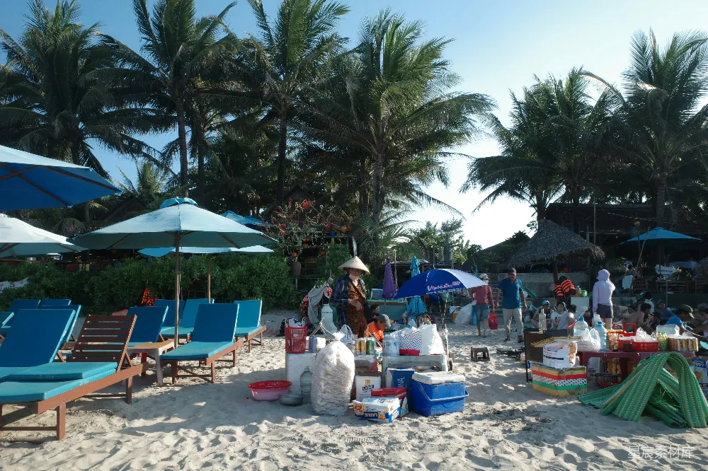 高清摄影 旅行 一个繁忙的热带海滩，有躺椅、遮阳伞和小贩。