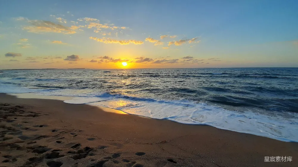 高清摄影 海滩上的太阳正在落下海面。