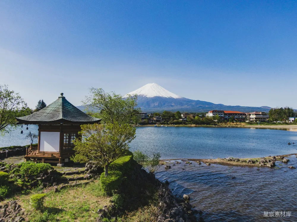 高清摄影 棕色和白色的房屋靠近湖和山，在蓝天下的白天景色是蓝色的。