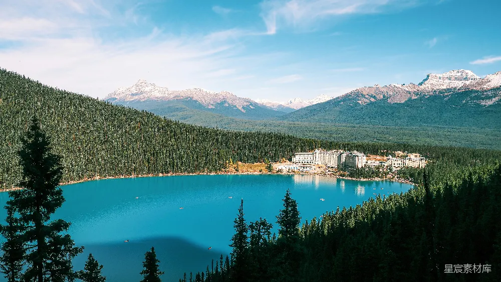 高清摄影 turquoise湖周围环绕着松树和山峦。
