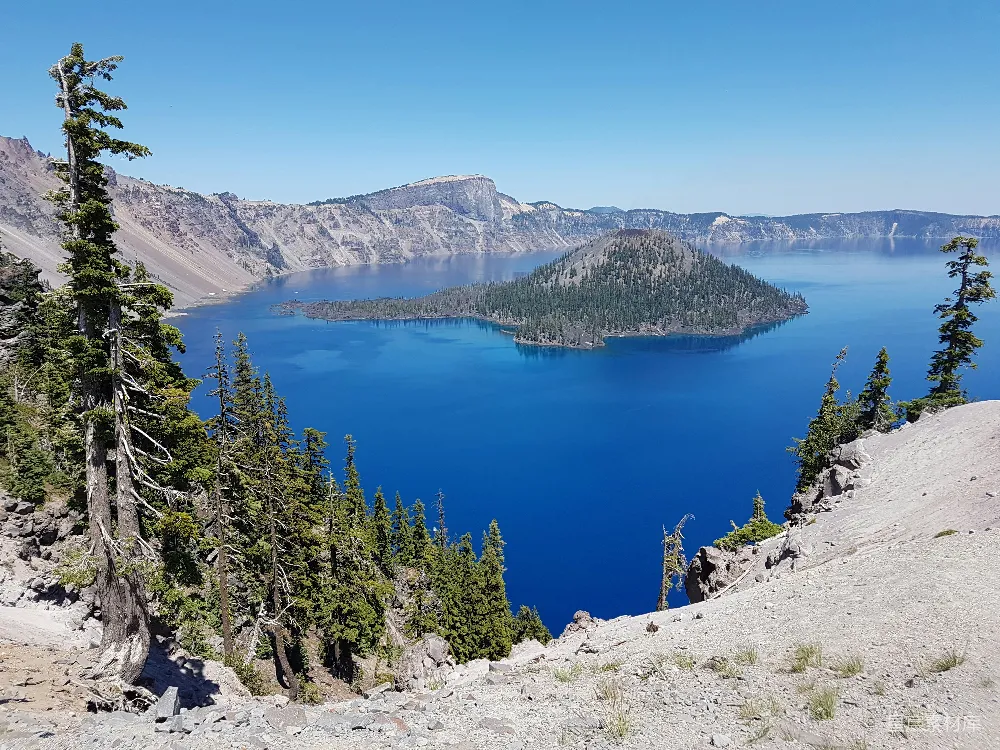 高清摄影 绿松树环绕在蓝湖附近的一座白岩石山的白天景色