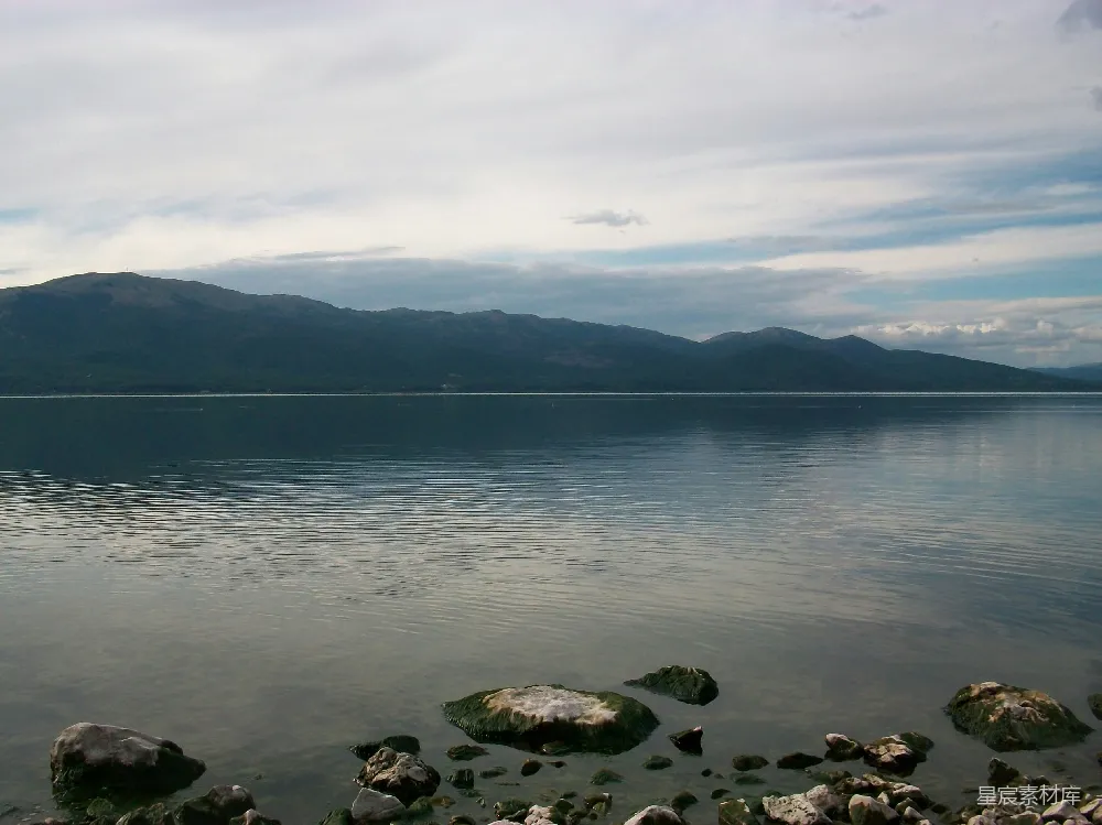 高清摄影 一片岩石嶙峋的海滩，背景是水面。