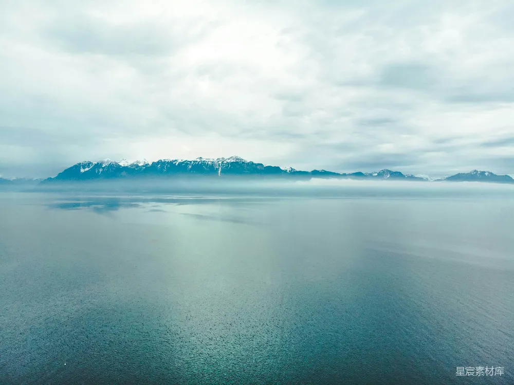高清摄影 雪覆盖的山傍海，白云下白色一片