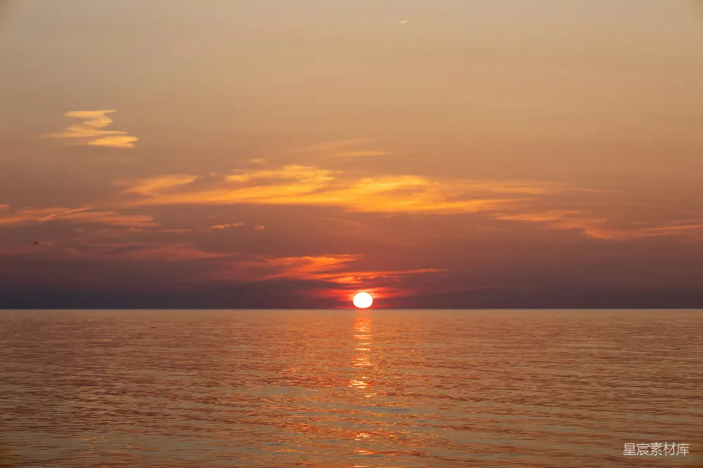 高清摄影 阴天时太阳正沉落在海洋之上。