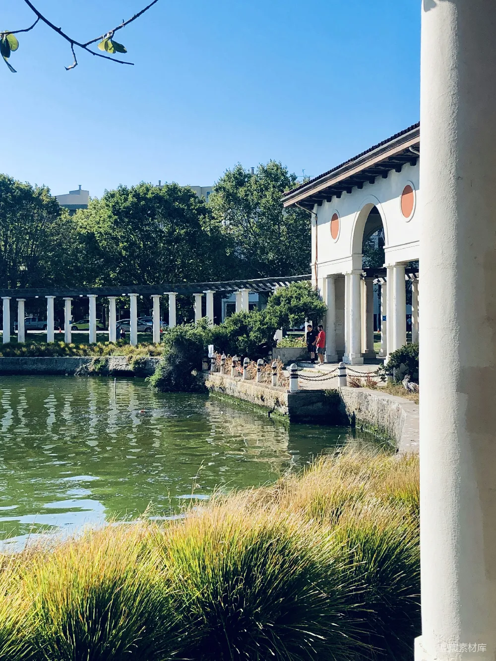 高清摄影 白天近河边的一栋白色和棕色混凝土建筑。