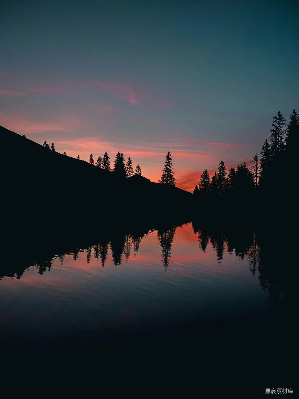 高清摄影 夕阳落下一片湖畔，背景是树木。