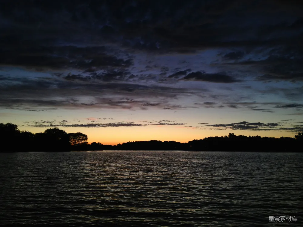 高清摄影 夕阳西下，映照在一片水域之上。