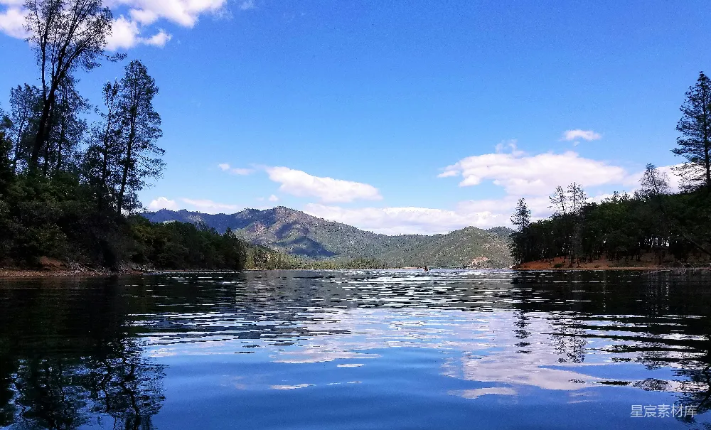 高清摄影 湖边有树木和山峰作为背景。