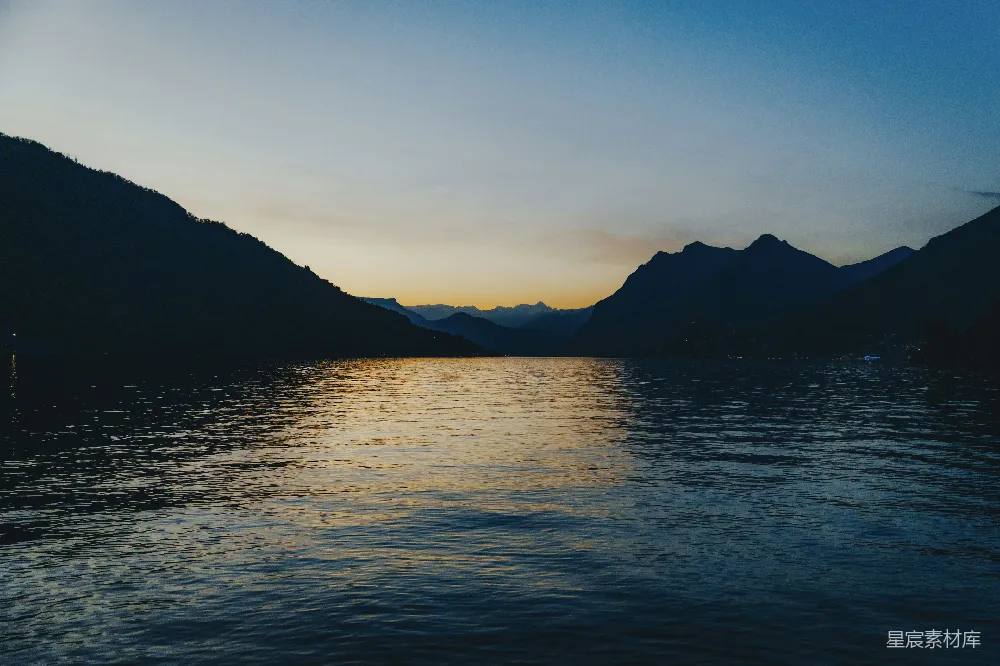 高清摄影 夕阳下山峦环绕着一片静湖。
