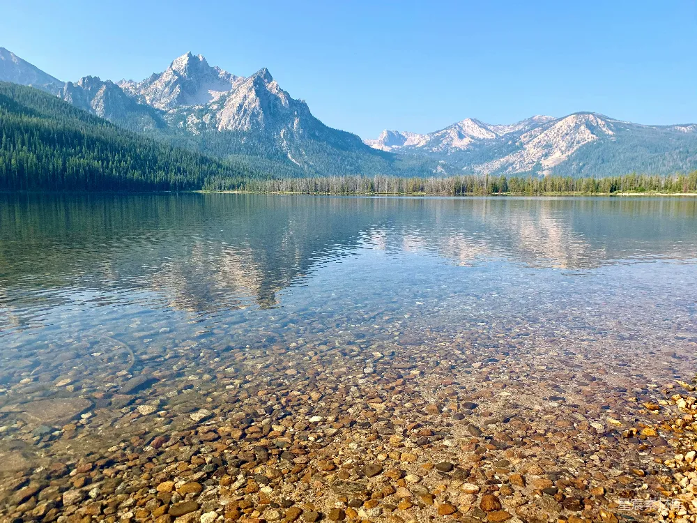 高清摄影 一个被山环绕的湖泊，湖中有岩石