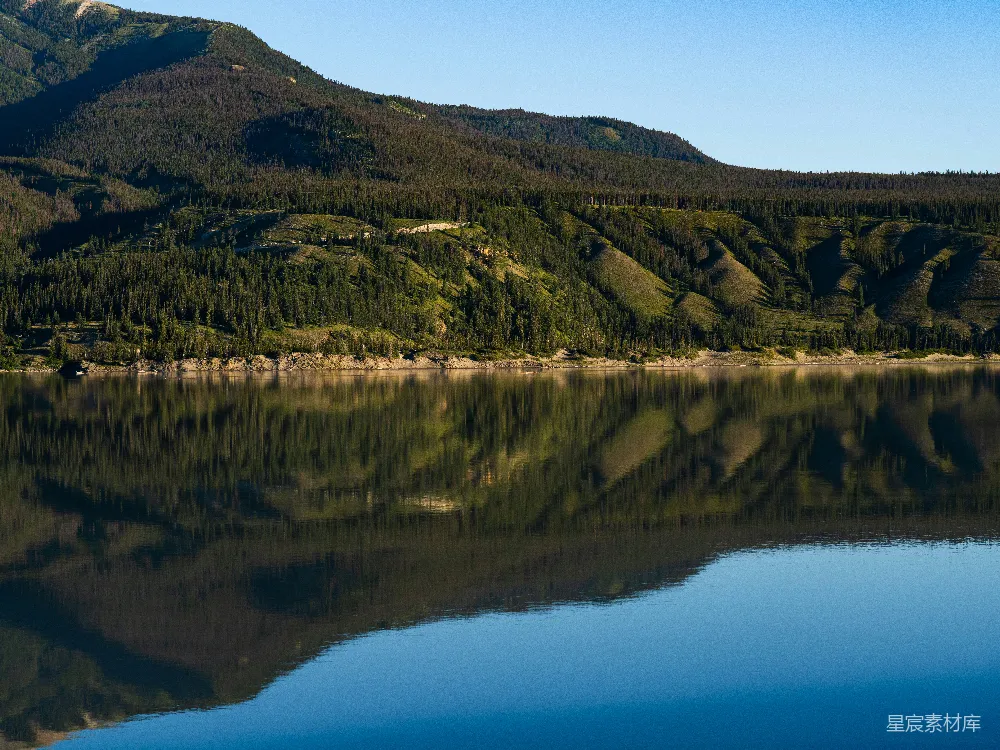 高清摄影 湖边有树木和山丘在背景中。