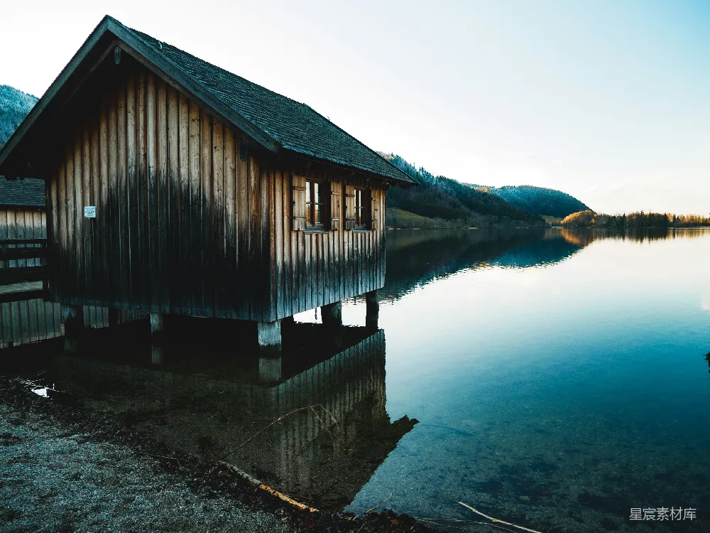 高清摄影 木头搭建的棕色小屋坐落在水上。