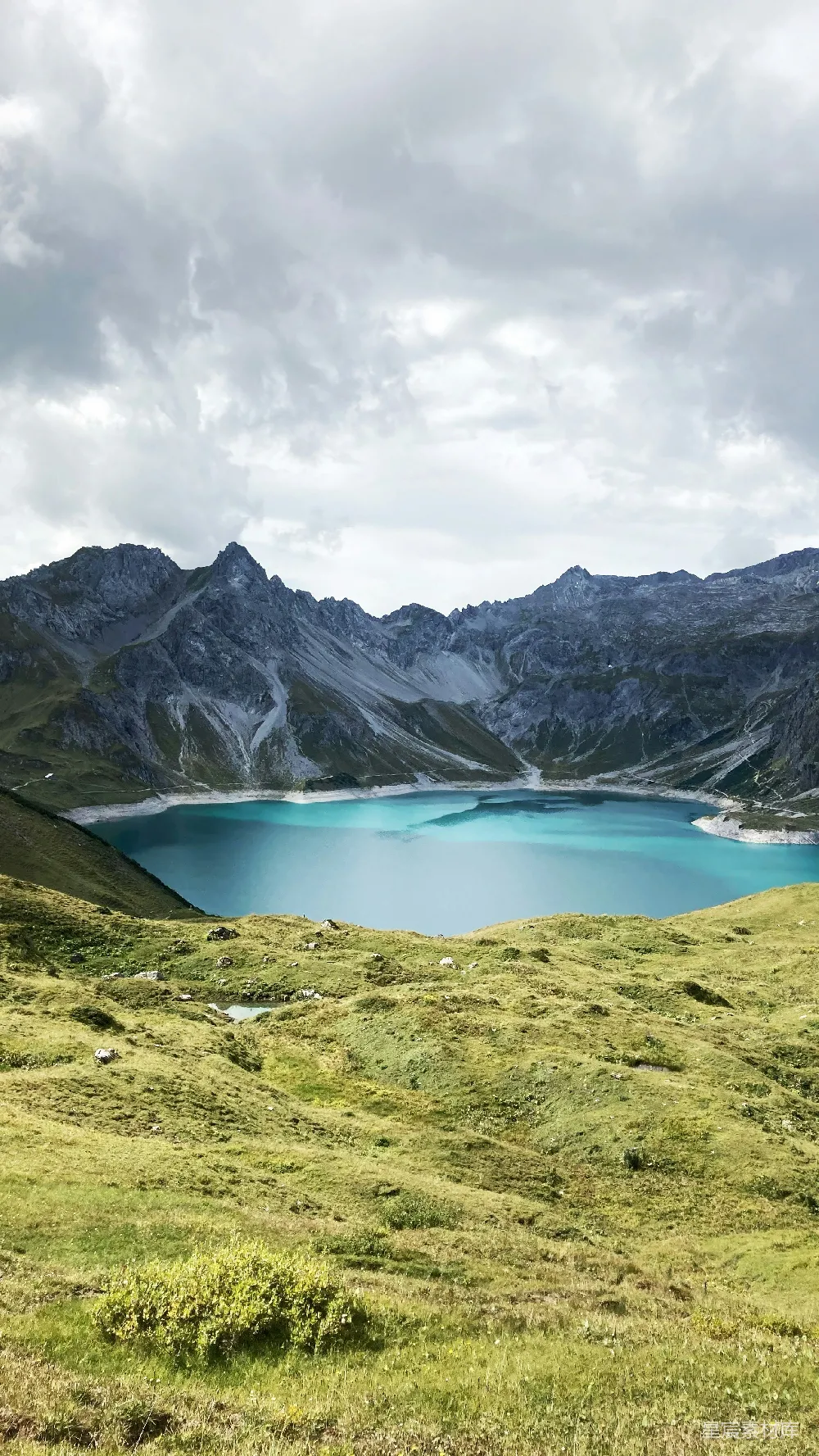 高清摄影 蓝湖周围环绕着山峦，在一片乌云密布的天空下。