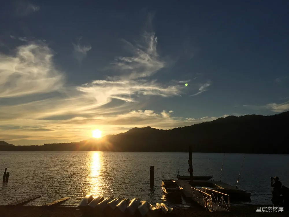 高清摄影 湖面平静下的夕阳美景，山峦在背景中衬托。
