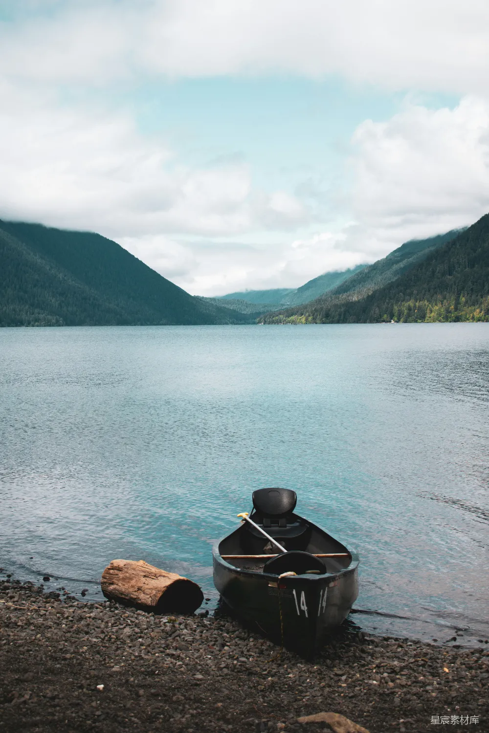 高清摄影 湖边一艘小船，背景是群山。