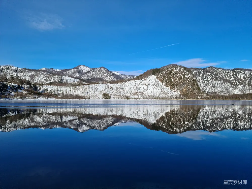 高清摄影 一片被雪山环绕的湖泊，在蓝天背景下闪闪发光。
