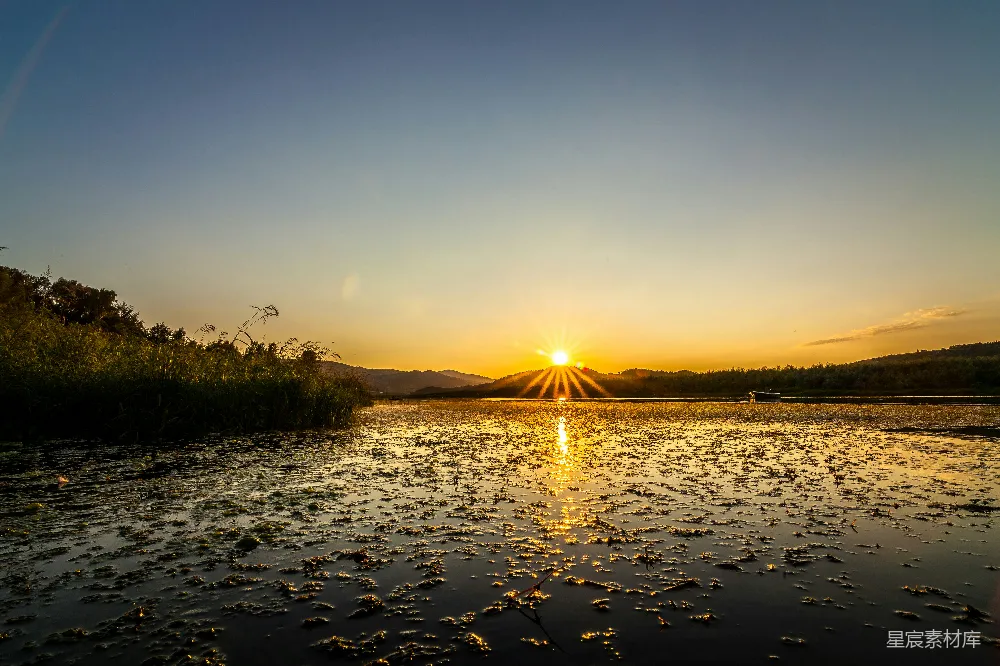 高清摄影 夕阳落下在一片水域之上