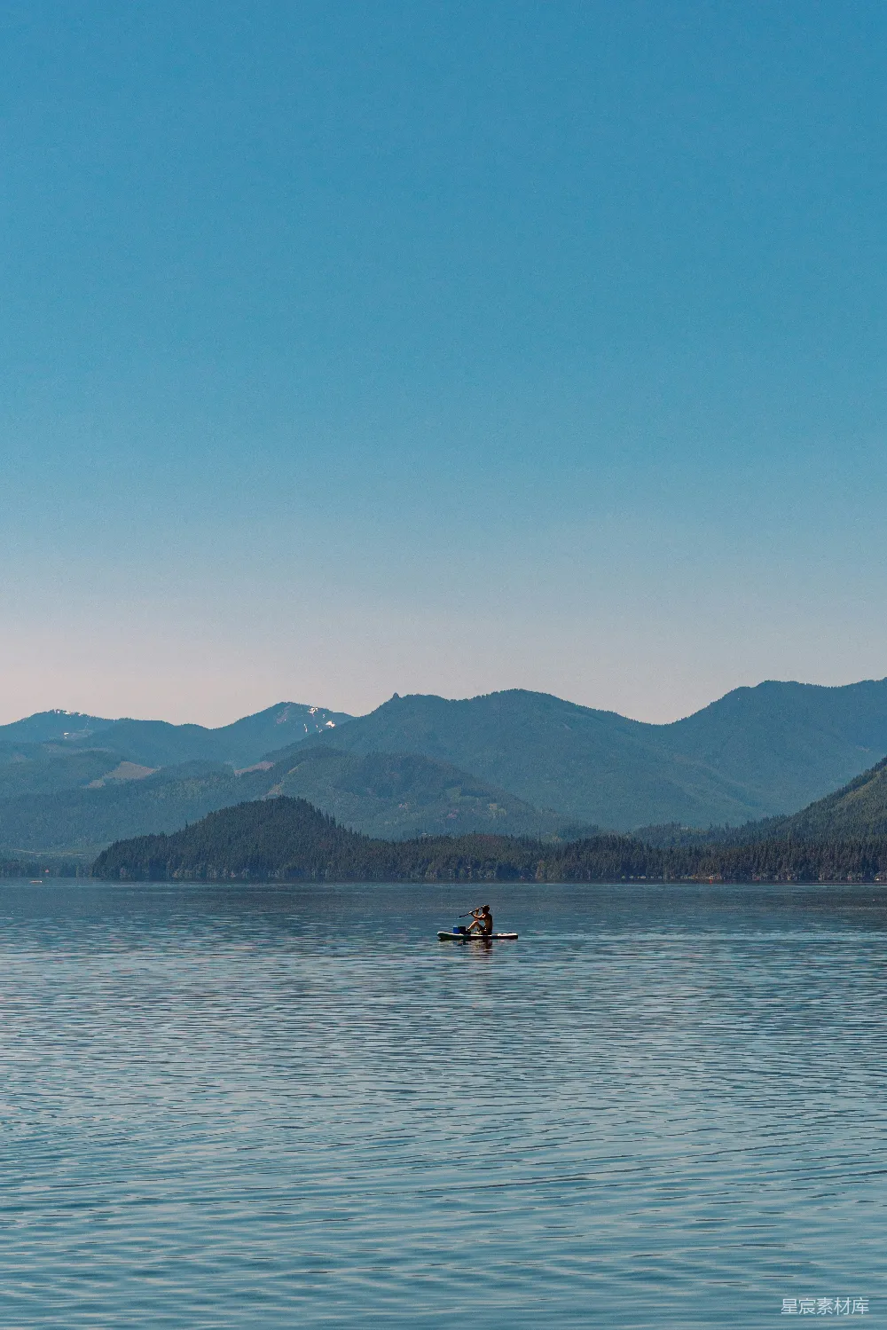 高清摄影 湖边一个人在山峦之间进行冲浪板运动。