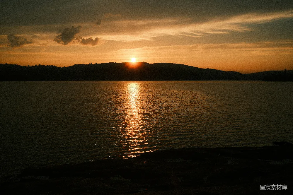 高清摄影  夕阳落下于一片水域之上