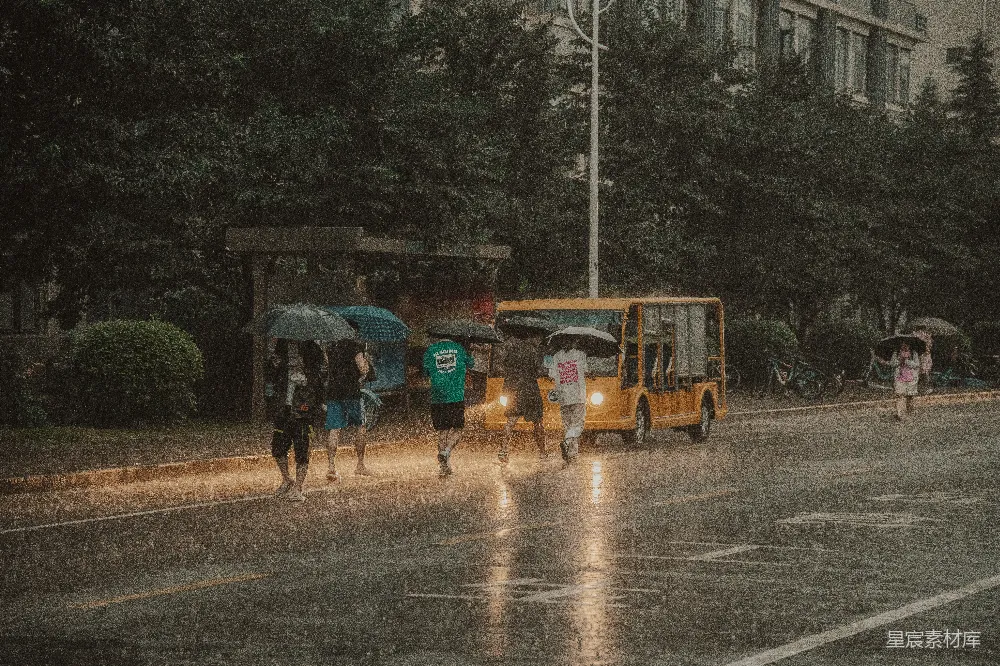 高清摄影  一群人在雨中打着伞走着