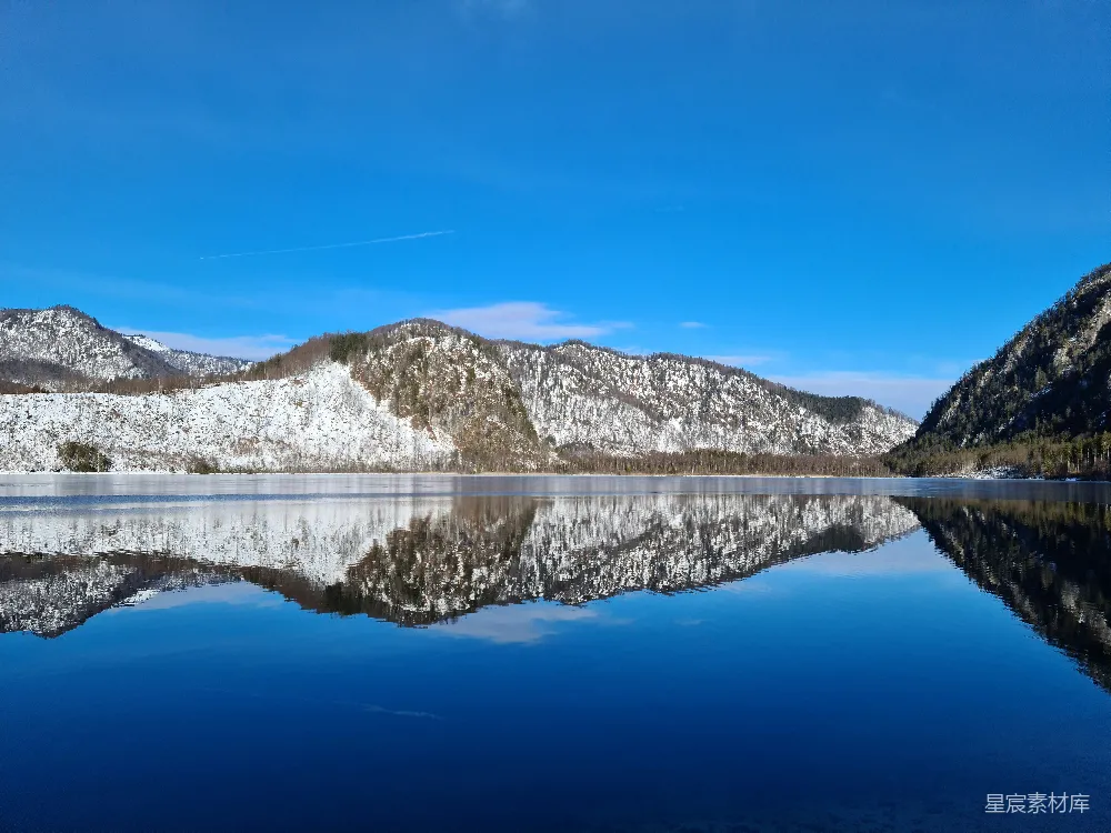 高清摄影 一个被雪覆盖的山峦环绕的湖泊和蔚蓝的天空