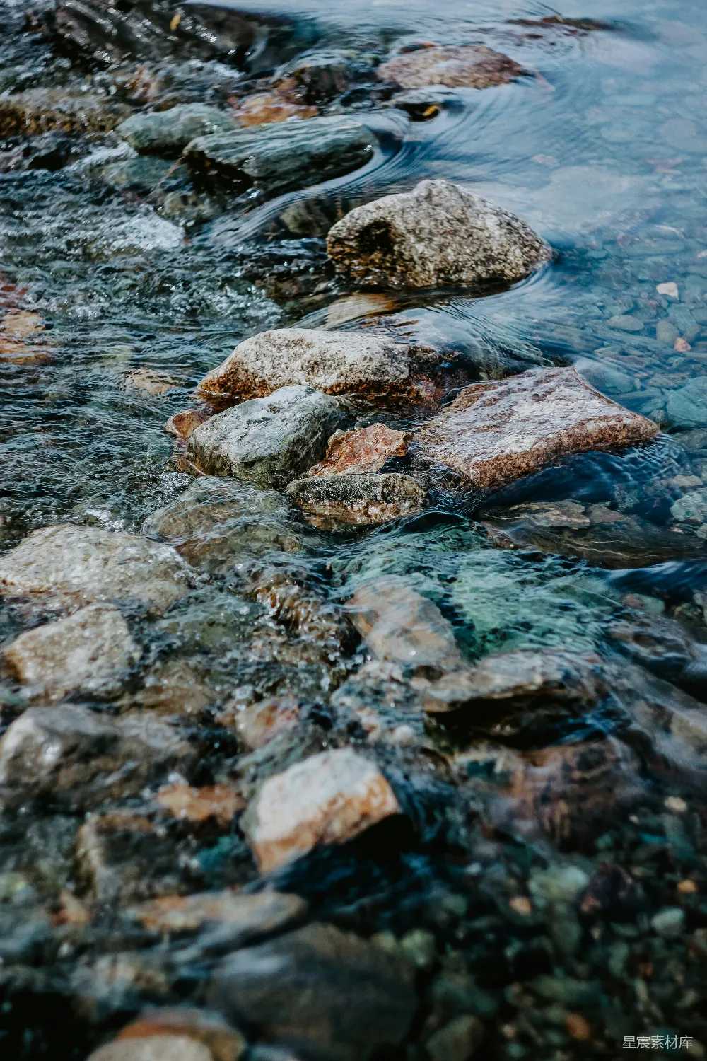 高清摄影 棕色和灰色的岩石漂浮在水面上。