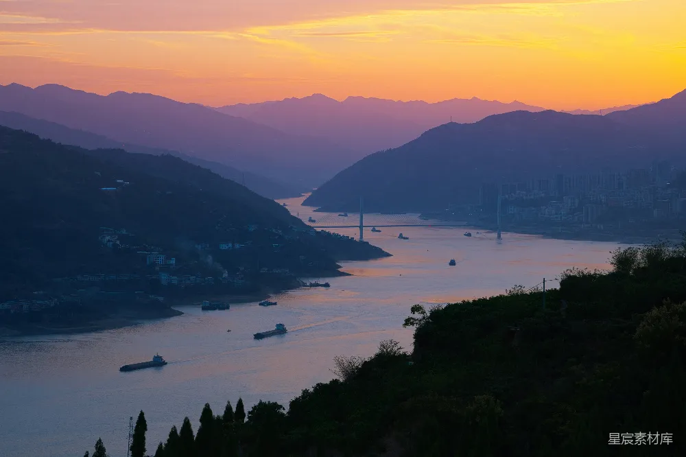 高清摄影 夕阳下的水面景色，背景是群山。