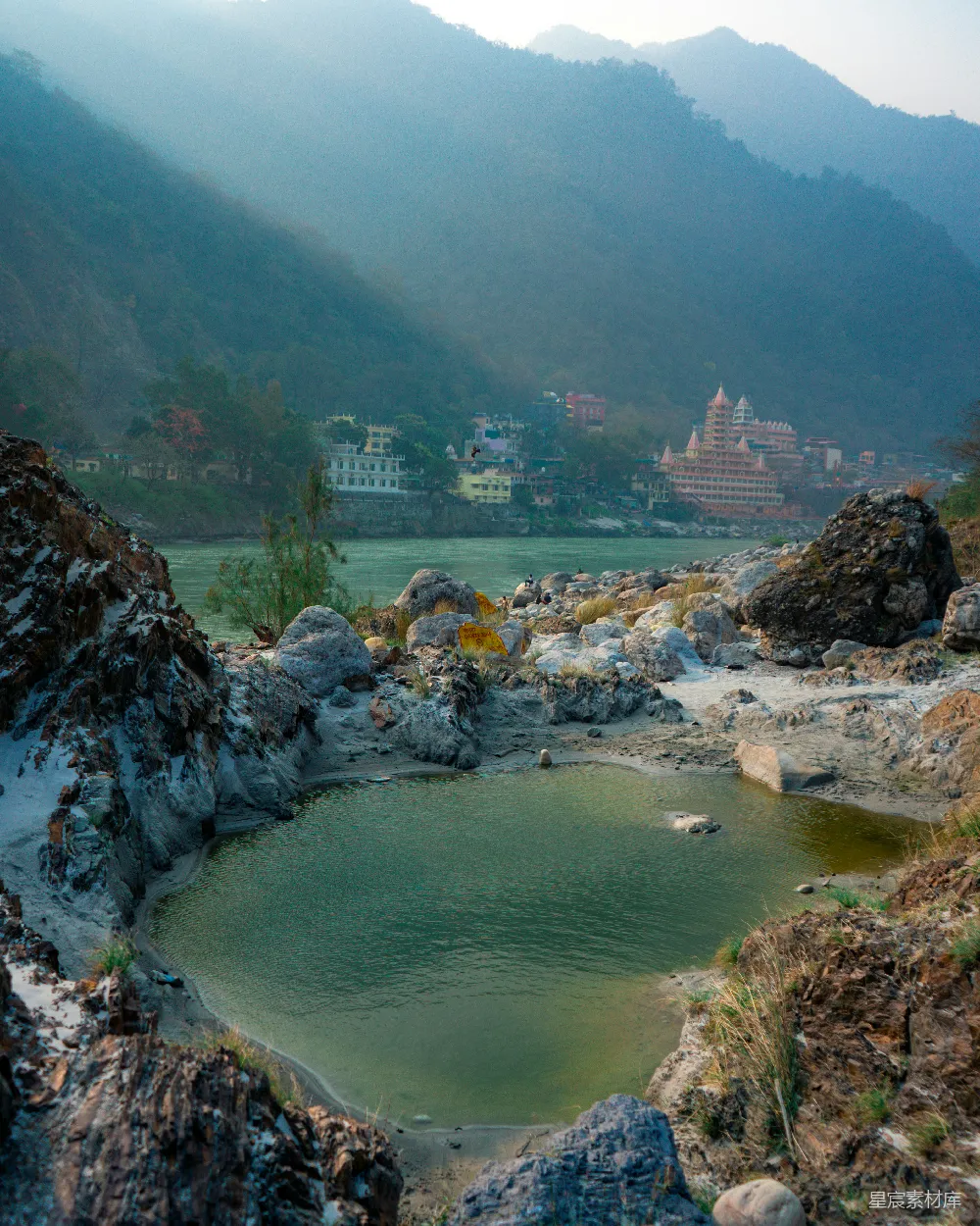 高清摄影 湖边有建筑，山峦在背景中。