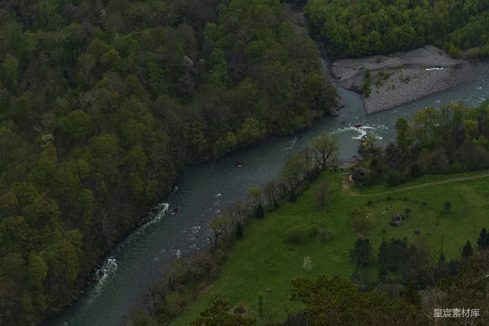 高清摄影 一条宽阔的河流流经一片葱郁的森林。