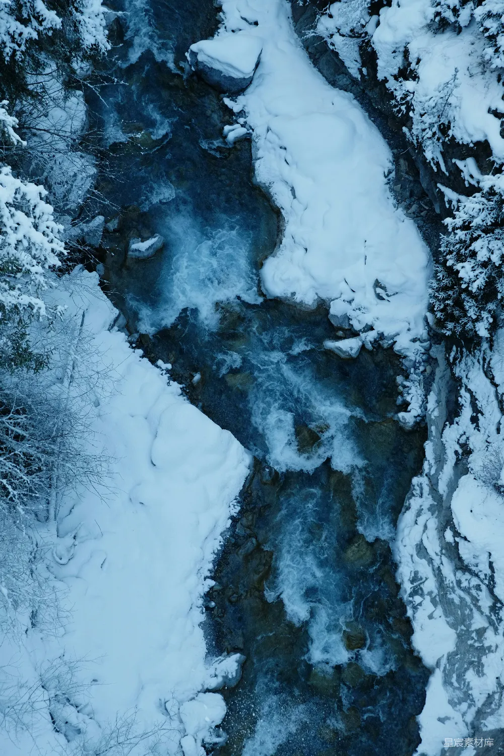 高清摄影 一条河流穿过一片覆雪的森林