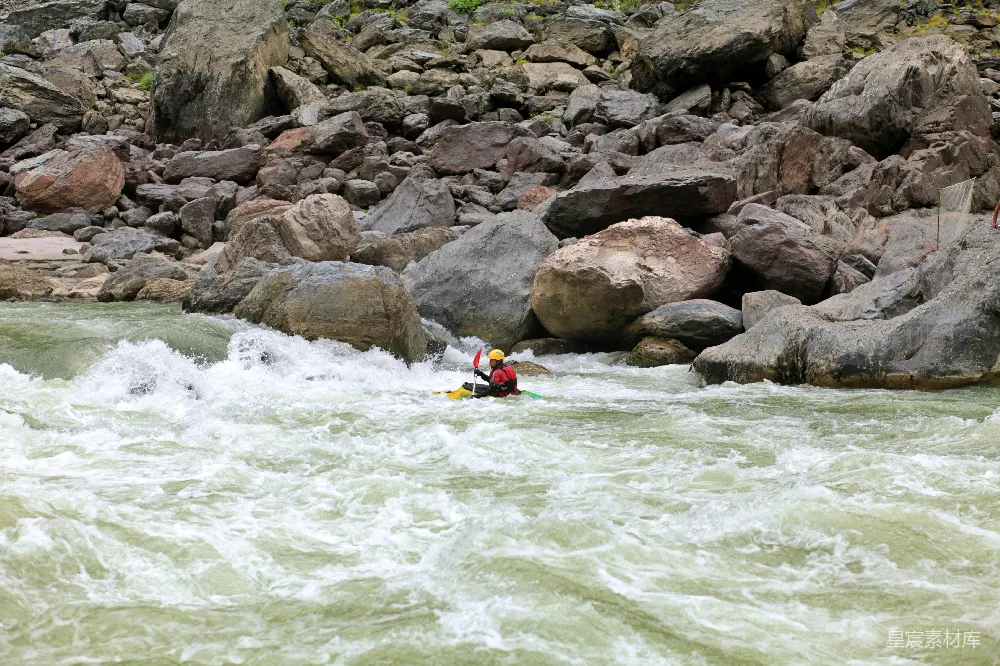 高清摄影 河岸边环绕着岩石的人坐在 kayak 中。