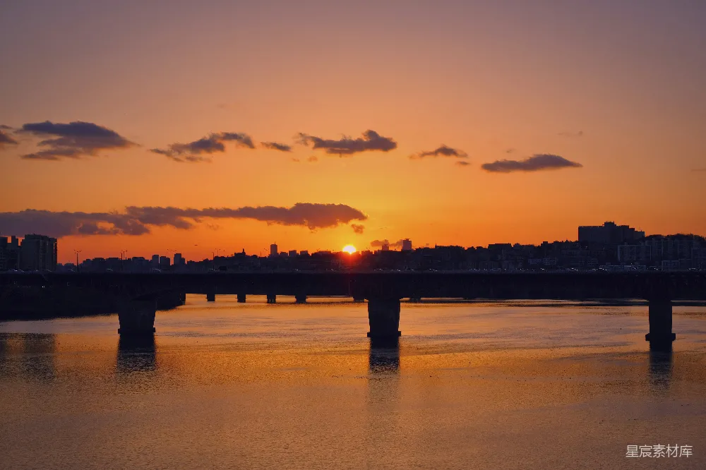 高清摄影 夕阳下桥的剪影映在水面上