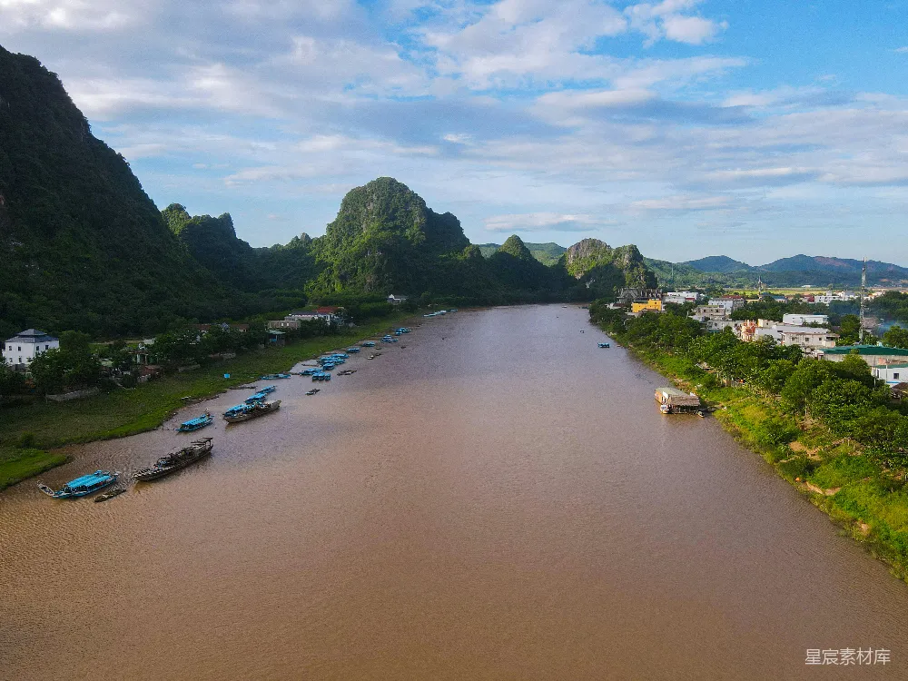 高清摄影 棕色河流流过绿色的喀斯特山峦，船儿在其中航行。