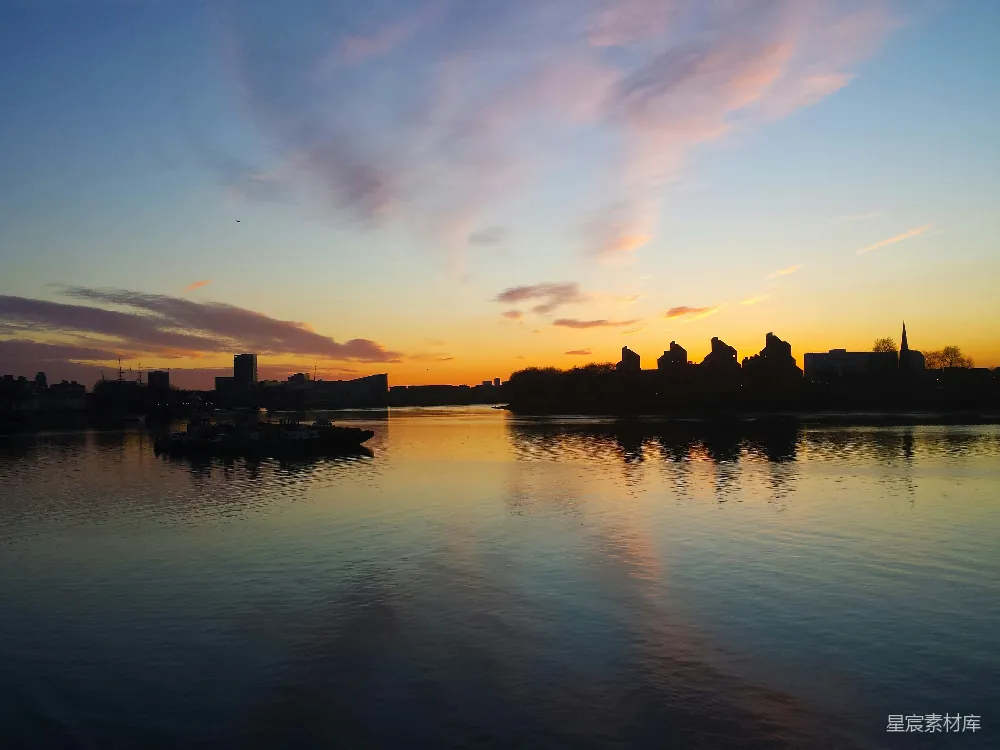 高清摄影 夕阳映照在一片水域之上，城廓隐约可见于背景中。