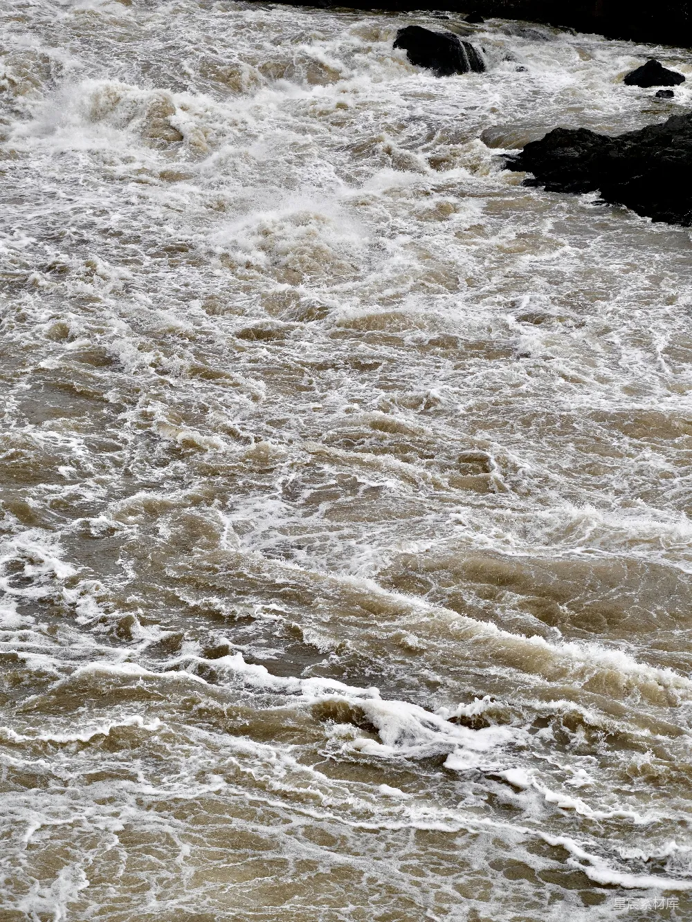 高清摄影  湍急浑浊的河水中有石头