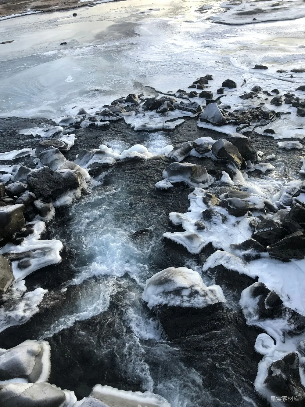 高清摄影 一条水流 surrounded 由冰雪覆盖的岩石环绕