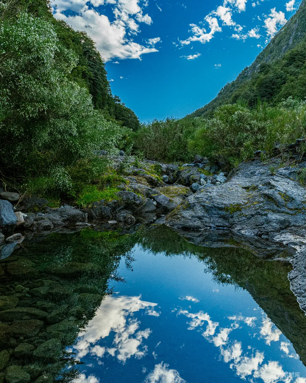 高清摄影 天空和山峦倒映在清澈的水面上。