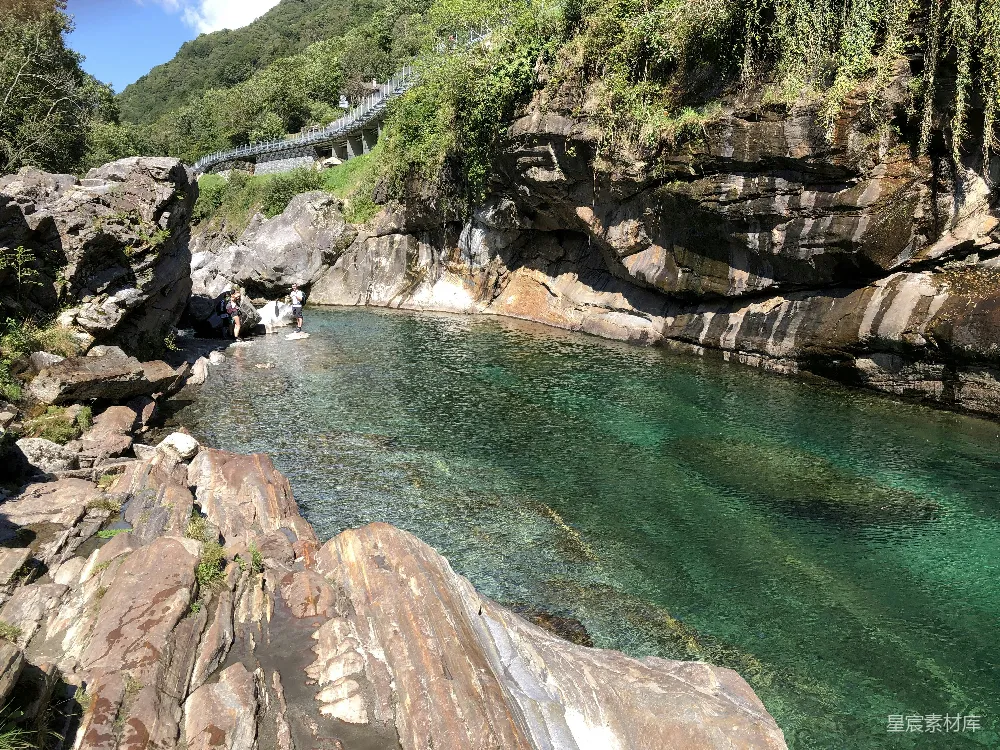 高清摄影 湖边有座桥，周围种着树木。