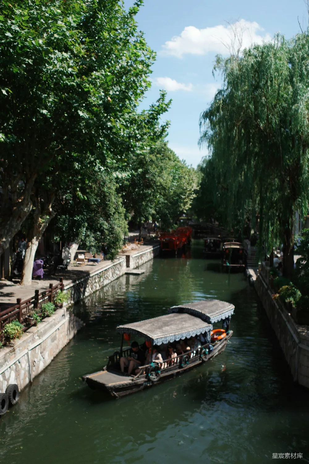 高清摄影 一条船在树影婆娑的运河中行驶。