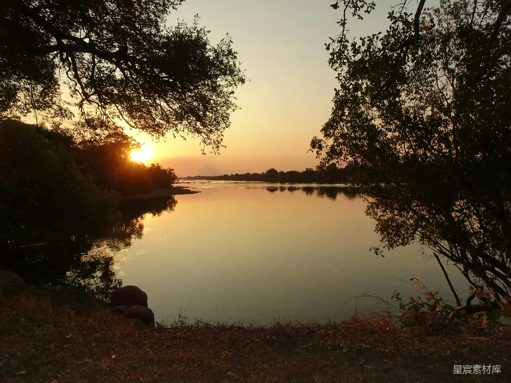 高清摄影 一圈树木围绕的水域和夕阳