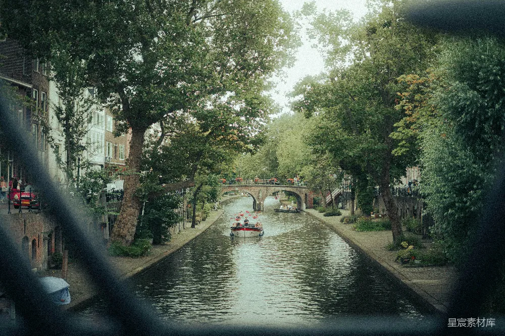 高清摄影 一艘船沿着河边行驶，旁边是高大的建筑物