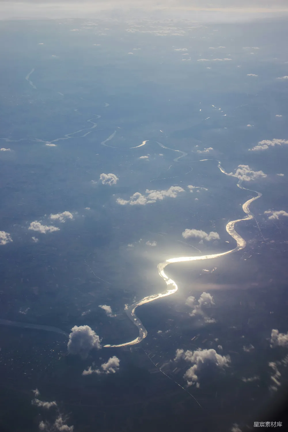 高清摄影 旅行 河面上空的俯视景象，阳光透过云层在蜿蜒的小河上反射。
