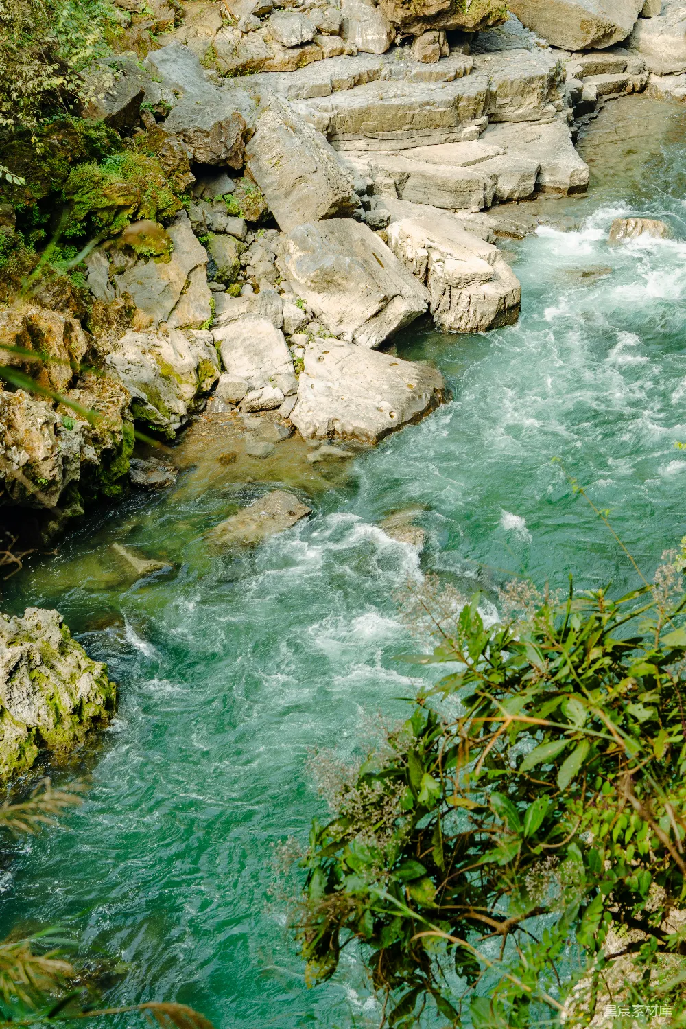 高清摄影 turquoise河流穿过岩石峡谷，两岸绿树环绕