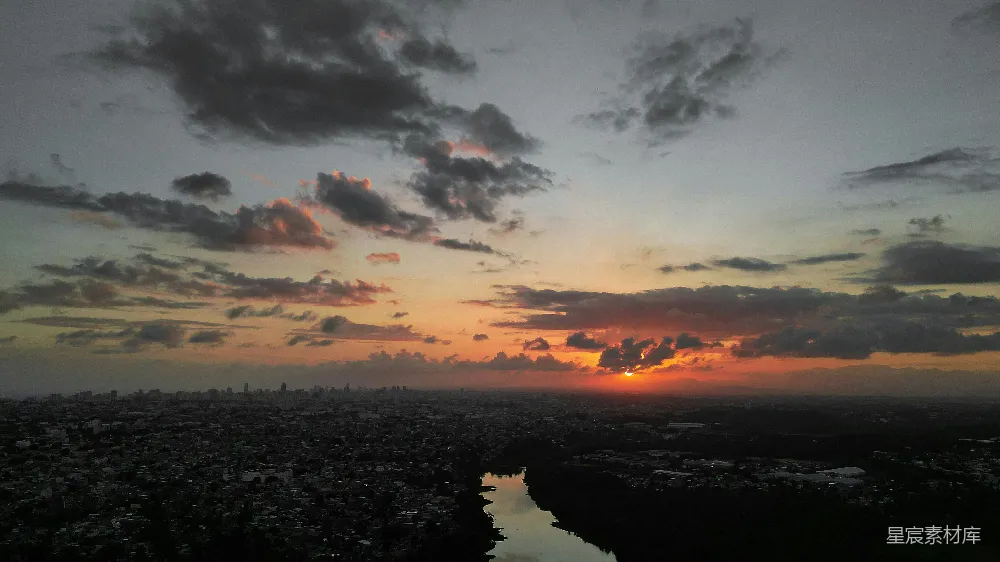 高清摄影 夕阳落下在一座城市和一片水域之上