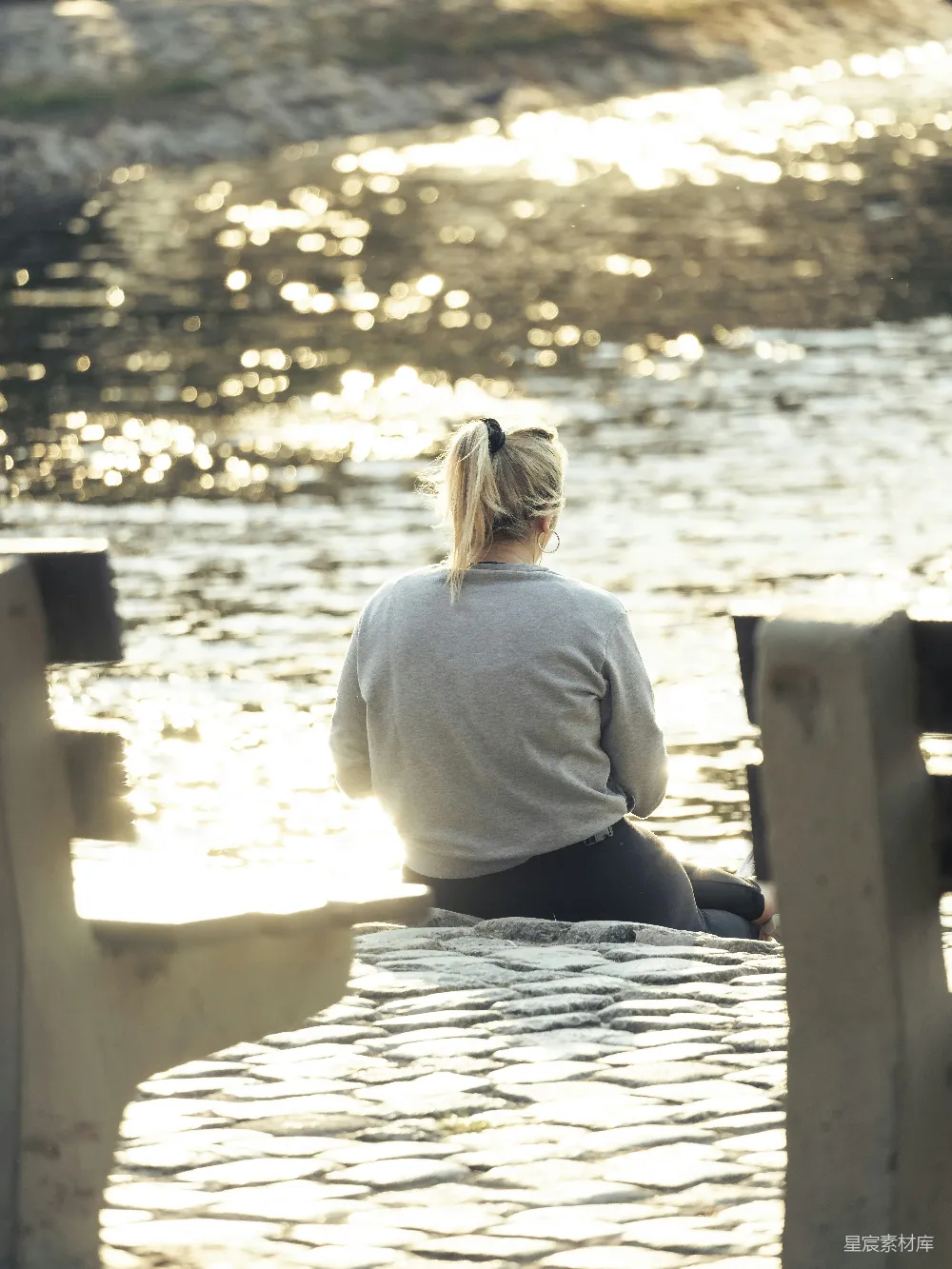 高清摄影 一个女人坐在码头上望着水面。