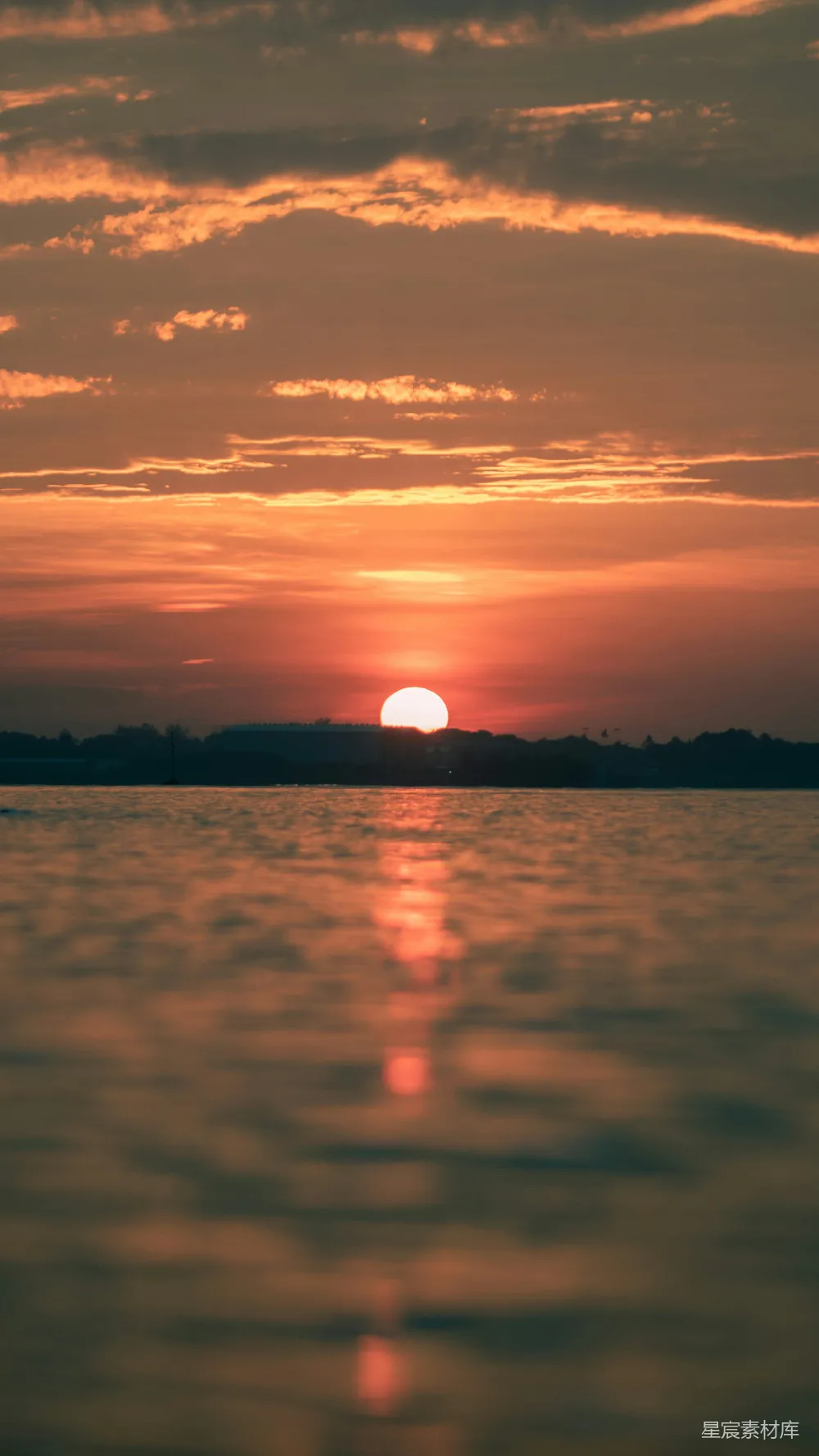 高清摄影 夕阳落下在一片水域之上