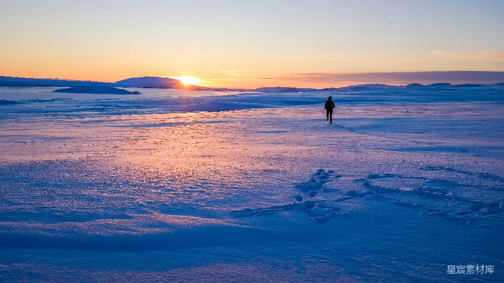 高清摄影 人在雪地上行走，迎着日出。